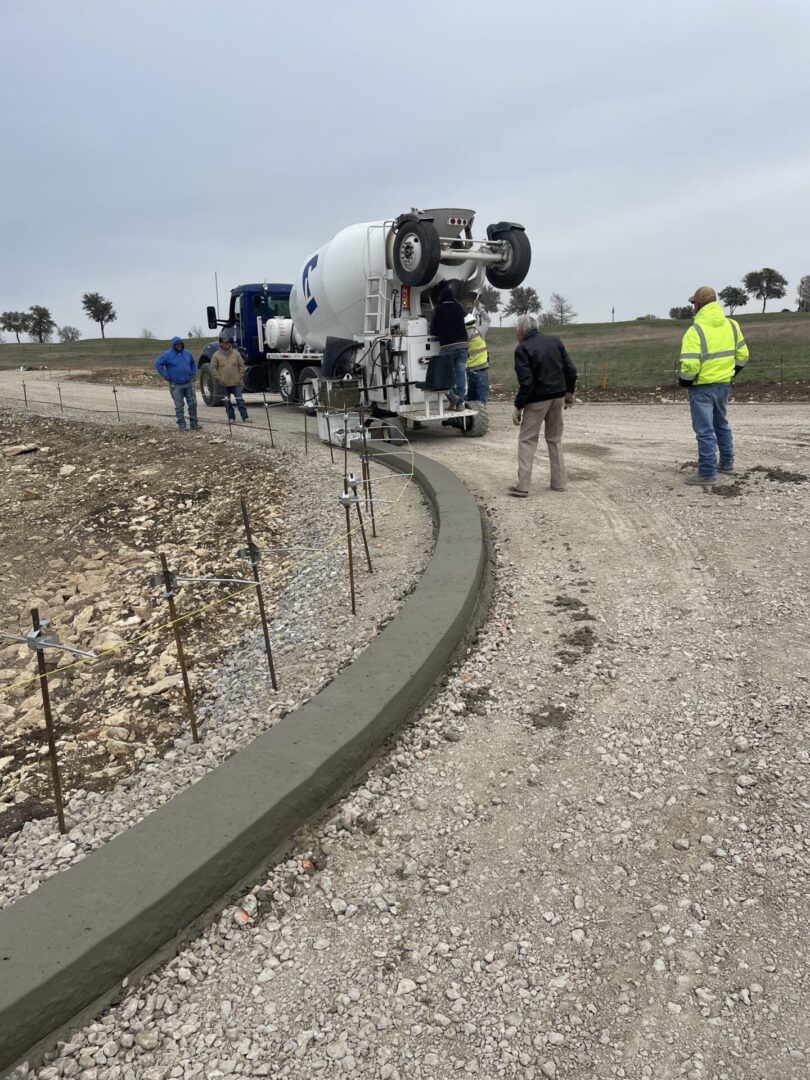 A cement truck is on the side of a road.