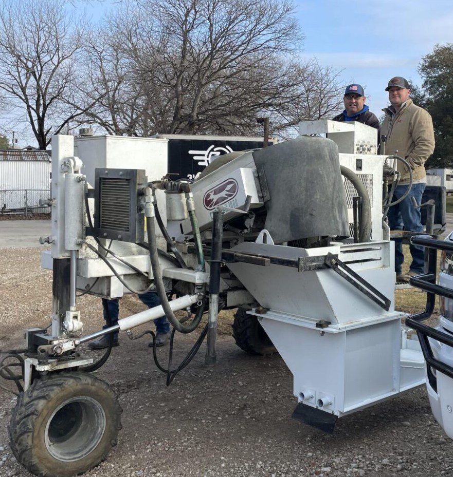 A man standing next to a white machine.