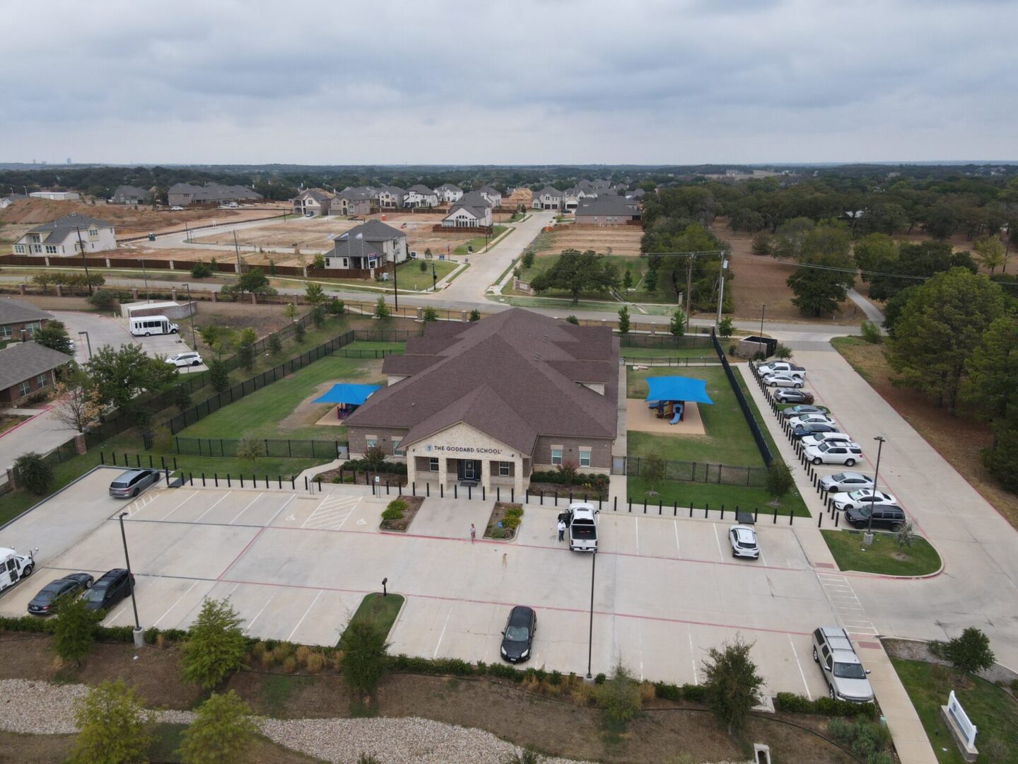 A large house with lots of cars parked in it.