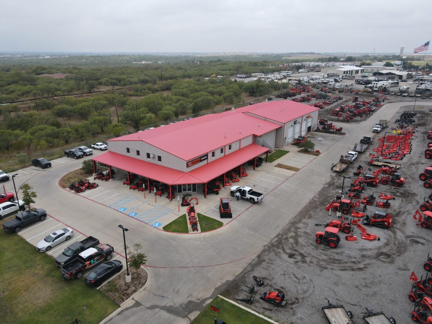 A large red building with many tractors parked in it.