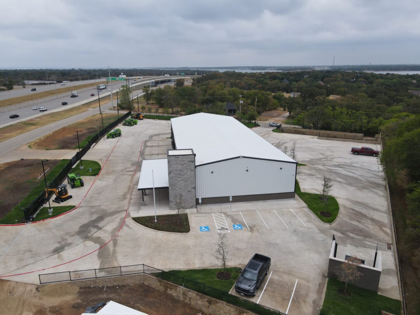 An aerial view of a building with a parking lot in the background.